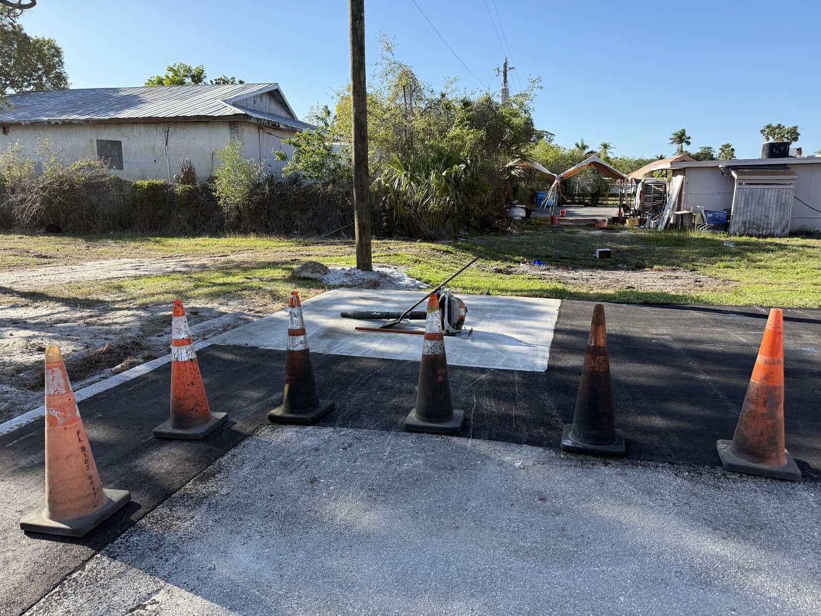 Asphalt patch work repair area coned off on a Cape Coral property