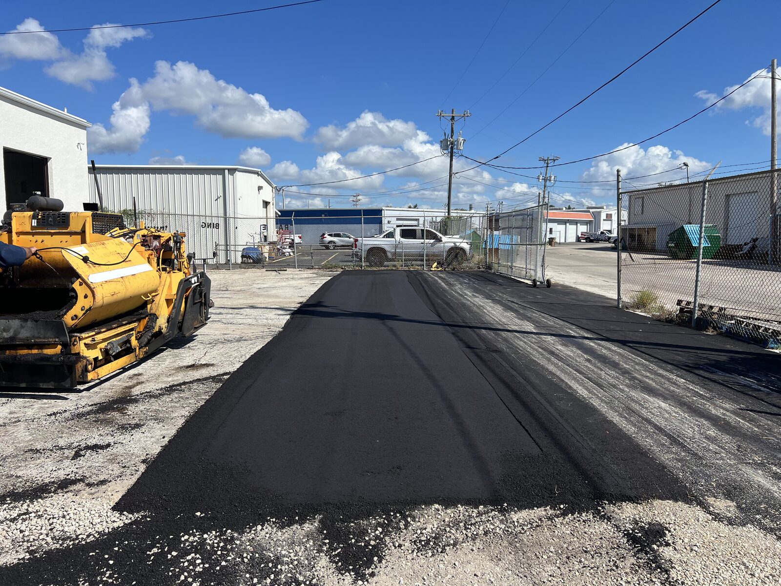 Asphalt paver laying hot mix asphalt on a commercial property in Lee County, Florida